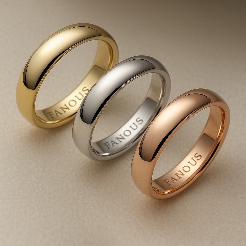 Trio of gold wedding bands in yellow, white, and rose gold, engraved with 'FANOUS'.